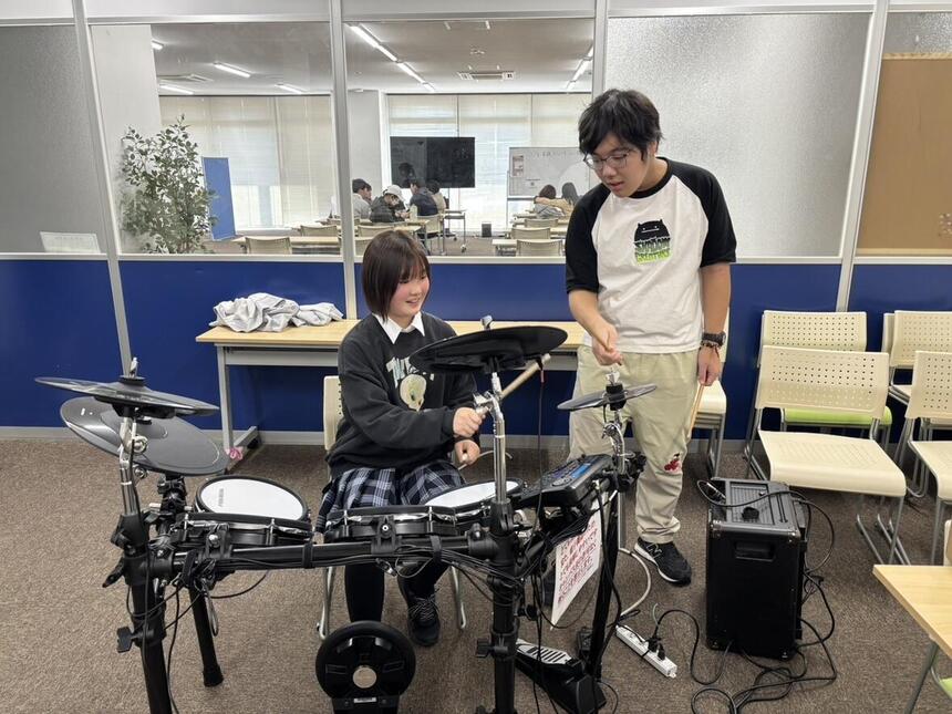 ドラムを教える生徒と教わって演奏してみる生徒