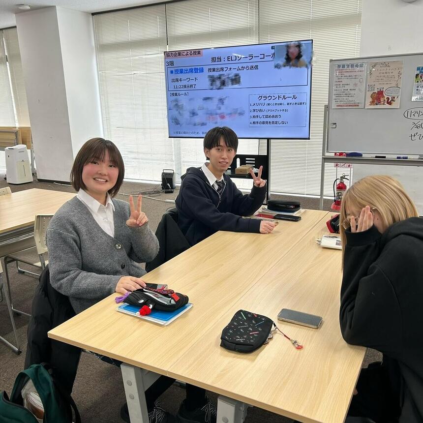 EX授業風景。生徒3人が同じ机にいる。