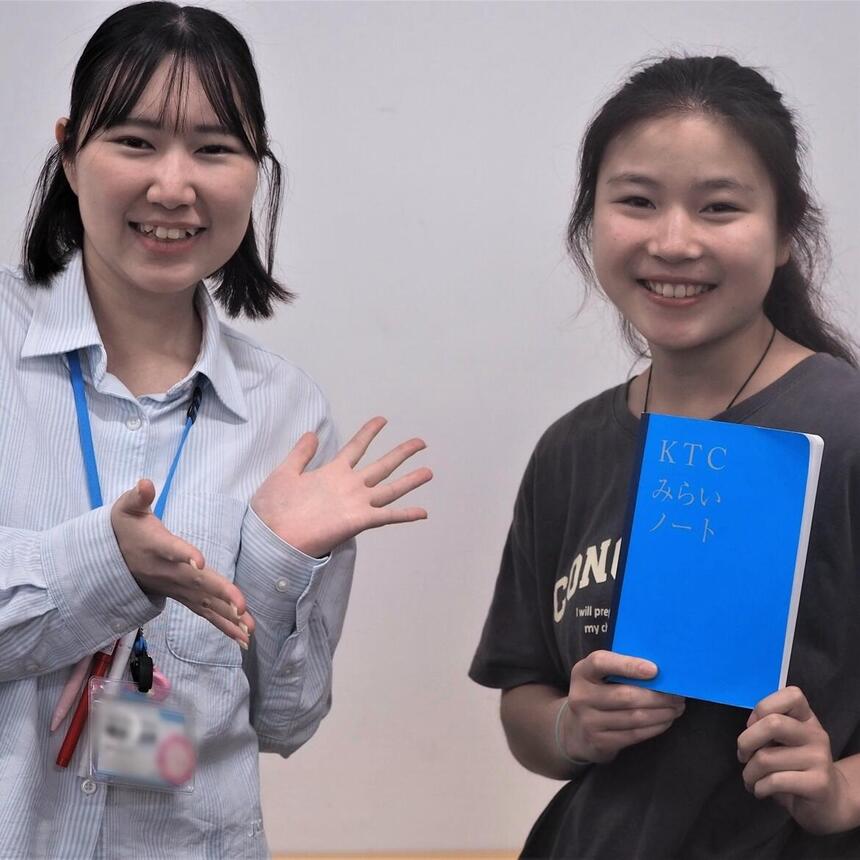 左がコーチ、右が生徒で笑顔で生徒がみらいノートを持っている写真