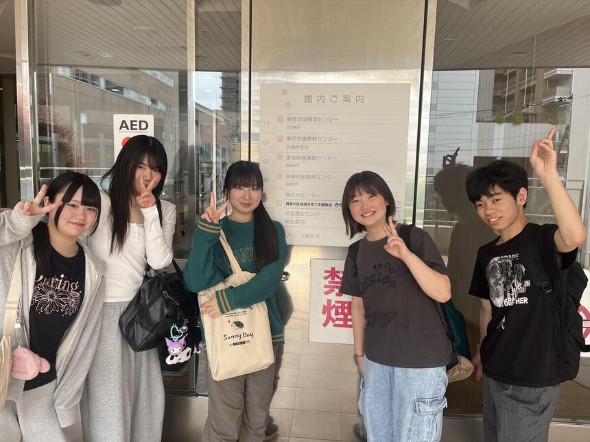 神奈川区地域子育て支援拠点かなーちぇ前で集合写真に写る男子高校生と女子高校生