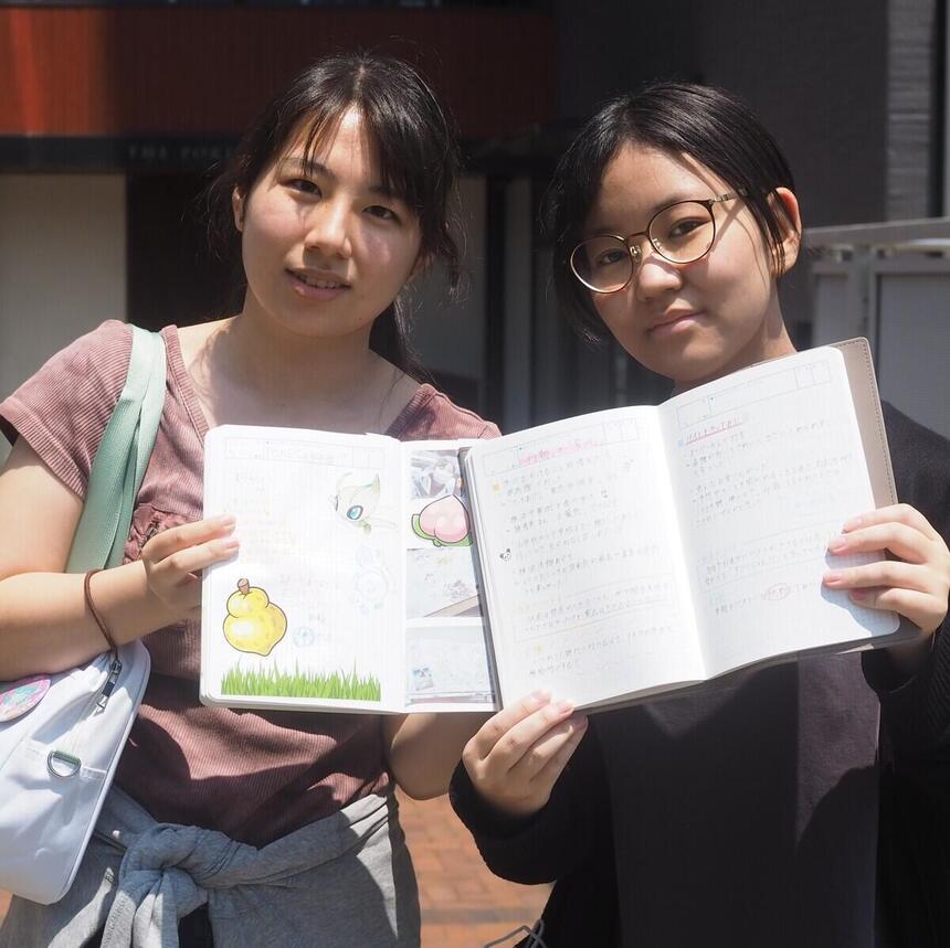 女子高校生二人がキャンパス前でみらいノートを手にしている写真