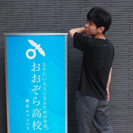 看板の前でポーズを取る男子高校生