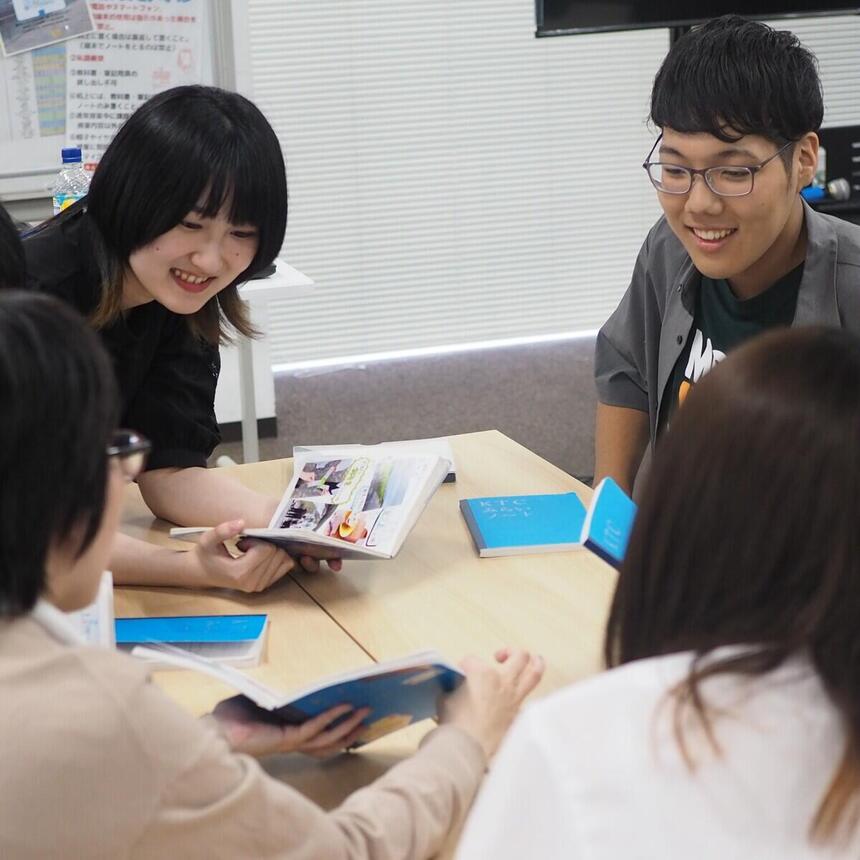高校生とコーチがみらいノート®を中心に笑いあっている写真