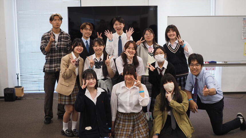 教室内で集合写真に写る先輩コーチの生徒