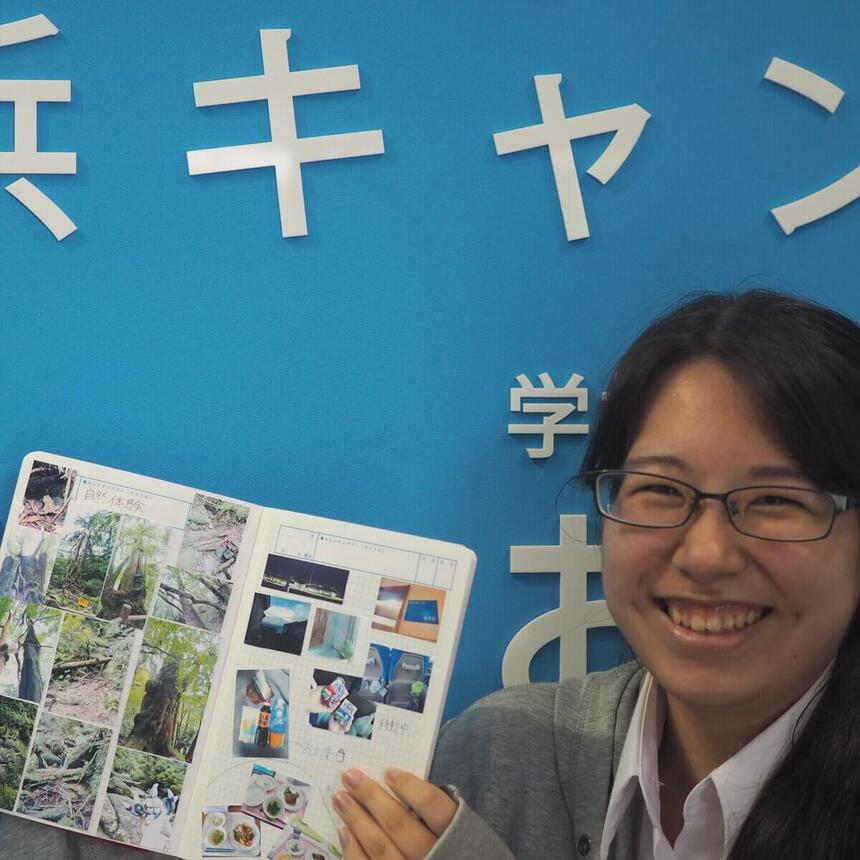 屋久島スクーリングの思い出ページを掲げる笑顔の女子高校生