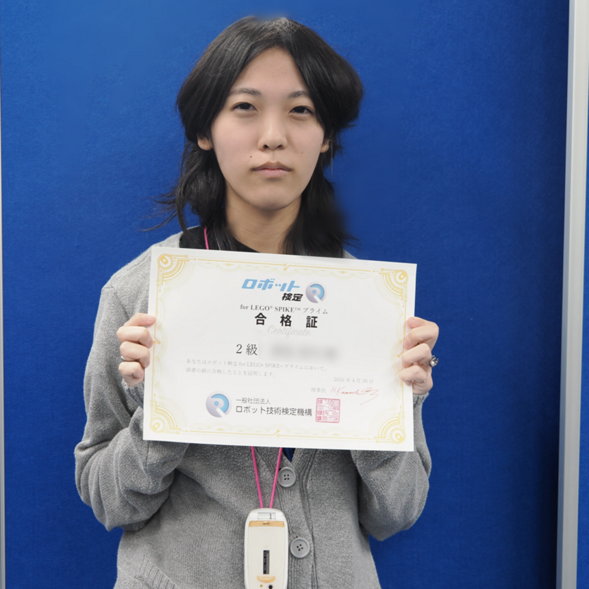 教室でロボット検定の合格証を手にしている女子高校生