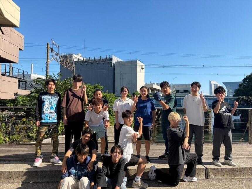キャンパスの前でポーズをとる生徒たちの集合写真