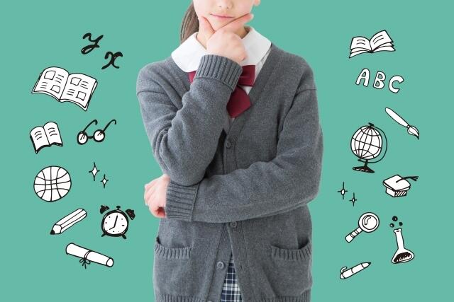 制服を着た女子生徒が顎に手を当て何か難しいことを考えている様子