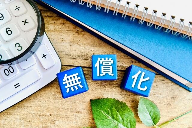 無償化という漢字三文字が電卓とノートの隣に並んでいる写真