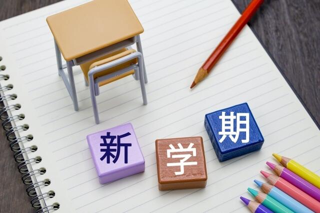 新学期というブロックや色鉛筆がノートの上に並べられている様子